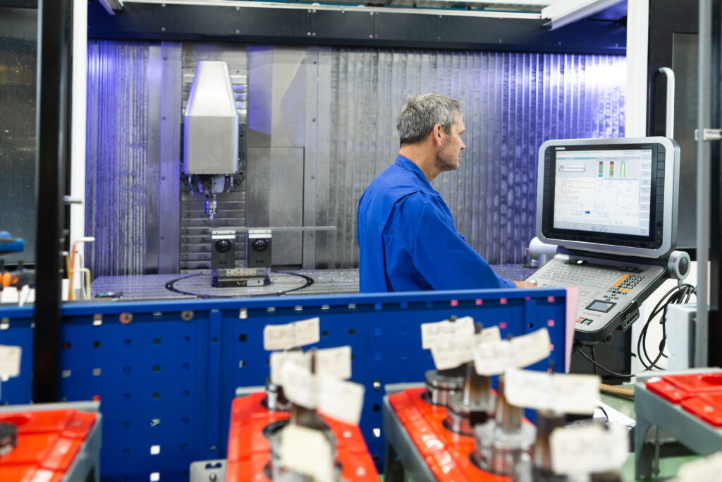 Mitarbeiter (Produktion) von Spikker Specials steuert Ausrüstung für die Produktion kritischer Maschinenkomponenten